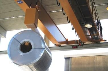 ABUS Kran transportiert Edelstahlröhre in halboffener Halle in Finnland 