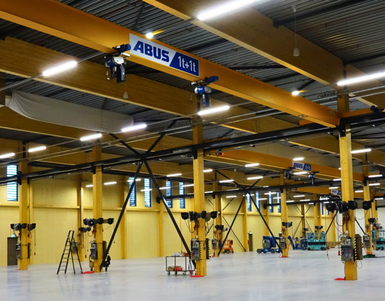 Ein gelber ABUS Kran in einer Produktionshalle von Blueprint Automation (BPA)