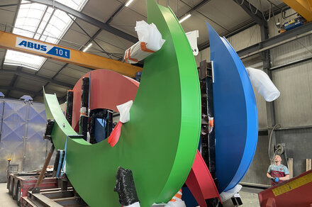 Großdimensionierte Bauteile werden mit einer ABUS Krananlage präzise in einer Industriehalle bewegt und positioniert.