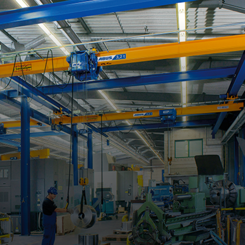 ABUS Deckenlaufkrane in einer Industriehalle mit Tragfähigkeit bis 8 t und Spannweite bis 25 m für platzsparenden Materialtransport.